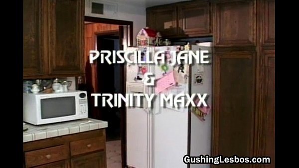 Girl-on-girl fake penis fucking in the kitchen